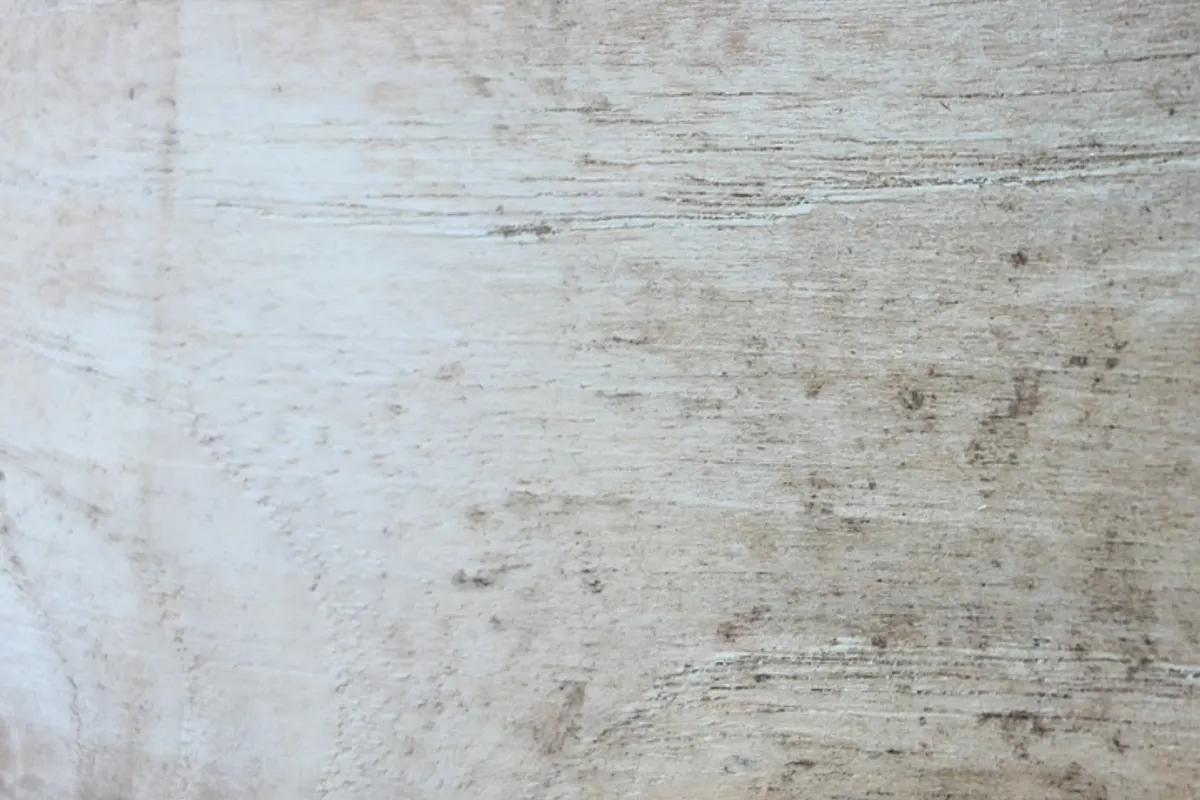 Pale, weathered, coated surface with linear marks; wood species not confirmed.